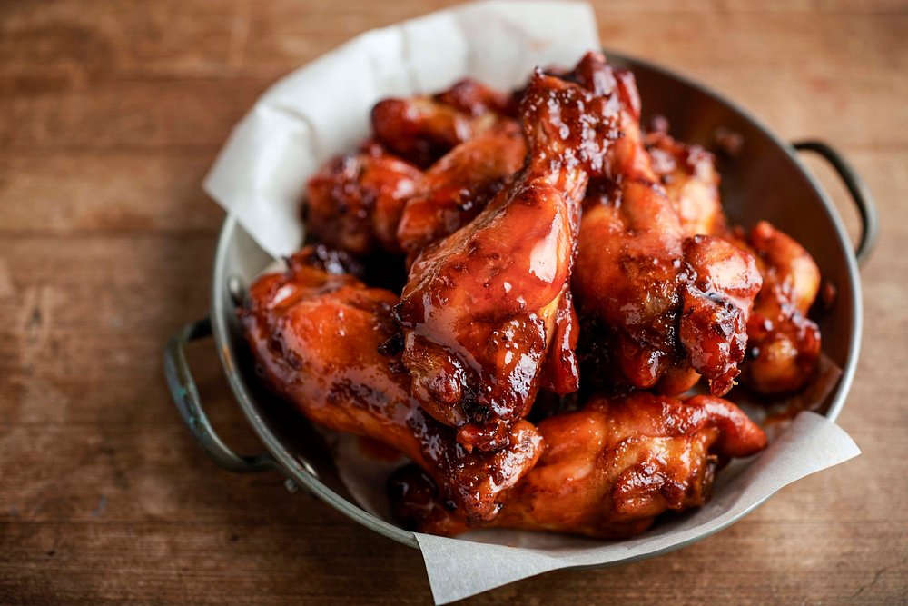 Bowl of glossy saucy chicken wings
